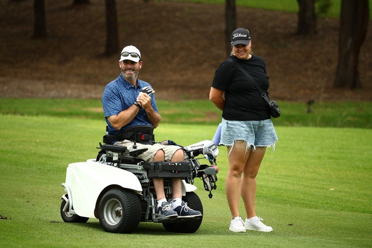 A person and person standing next to a golf cart AI-generated content may be incorrect.